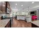 Open kitchen with granite counters, stainless appliances, and wood floors overlooking the living area at 64 Thousand Oaks Ct, Clayton, NC 27527