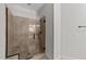 Tiled walk-in shower with glass door and bronze fixtures in neutral-toned bathroom at 64 Thousand Oaks Ct, Clayton, NC 27527