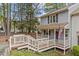 Side view of a cozy home, showcasing a covered porch, American flag, and natural surroundings at 6568 English Oaks Dr, Raleigh, NC 27615