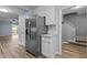 Spacious kitchen featuring stainless steel refrigerator, white cabinets, and wood-look flooring at 6568 English Oaks Dr, Raleigh, NC 27615