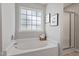 Inviting bathroom showcasing a soaking tub, framed artwork, and a glass-enclosed shower at 6863 Paint Rock Ln, Raleigh, NC 27610