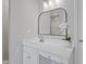 Beautiful bathroom features white cabinetry, modern fixtures, and a large framed mirror at 6863 Paint Rock Ln, Raleigh, NC 27610