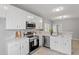 Well-lit kitchen featuring modern appliances, white cabinets, and quartz countertops and stainless steel dishwasher at 6863 Paint Rock Ln, Raleigh, NC 27610