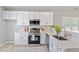 Bright kitchen featuring white cabinets, stainless steel appliances, quartz countertops and subway tile backsplash at 6863 Paint Rock Ln, Raleigh, NC 27610