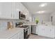 Bright kitchen features white cabinets, stainless steel appliances, and tiled backsplash at 6863 Paint Rock Ln, Raleigh, NC 27610