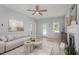 Inviting living room boasts neutral decor, ceiling fan, lots of natural light, and comfortable sofa at 6863 Paint Rock Ln, Raleigh, NC 27610