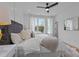 A bright bedroom with a cozy bed, a faux fur rug, a ceiling fan, and a window at 700 W North St # 101, Raleigh, NC 27603