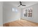 This bedroom is bright with two windows and light hardwood floors, and a ceiling fan at 700 W North St # 101, Raleigh, NC 27603