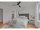 A bright bedroom with a cozy bed, a faux fur rug, a ceiling fan, and a window at 700 W North St # 101, Raleigh, NC 27603