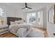A bright bedroom with a cozy bed, a faux fur rug, a ceiling fan, and a window at 700 W North St # 101, Raleigh, NC 27603