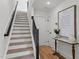 Inviting entryway with wood stairs, black railing, wood floors, and a charming decor accent table at 700 W North St # 101, Raleigh, NC 27603