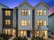 Stylish townhome exterior showcasing a combination of white and grey siding, black window frames, and manicured landscaping at 700 W North St # 101, Raleigh, NC 27603