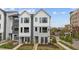 Two-story townhouse exterior featuring white siding, black framed windows, and a well-maintained front yard at 700 W North St # 101, Raleigh, NC 27603