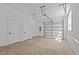 Spacious garage with an automatic door, concrete floor, and white walls at 700 W North St # 101, Raleigh, NC 27603