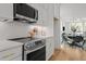 Modern kitchen with stainless steel appliances, white cabinets, and a geometric tile backsplash at 700 W North St # 101, Raleigh, NC 27603