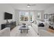 Living room with a white sofa, large windows, and a black console at 700 W North St # 101, Raleigh, NC 27603