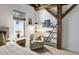Cozy bedroom featuring a comfortable chair, warm lighting, and exposed beams at 701 W Trinity Ave # 116, Durham, NC 27701