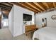 Bedroom features exposed wood beams, a modern dresser, and a wall-mounted television at 701 W Trinity Ave # 116, Durham, NC 27701