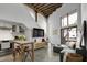 Bright living room featuring a modern table, wood beams, and a large window at 701 W Trinity Ave # 116, Durham, NC 27701