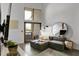 Bright living room area with a large window and a comfortable gray chaise lounge sofa at 701 W Trinity Ave # 116, Durham, NC 27701