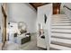 Spacious living room with stairs, wood beams, and modern gray chaise lounge sofa at 701 W Trinity Ave # 116, Durham, NC 27701
