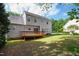 Backyard featuring a wooden deck, light gray siding, a manicured lawn and beautiful landscaping at 704 Voyager Pl, Durham, NC 27712