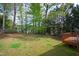 Expansive backyard featuring a lush lawn, mature trees, and a wooden deck, creating a serene outdoor living space at 704 Voyager Pl, Durham, NC 27712