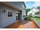 Backyard featuring a wooden deck, light gray siding, and a glimpse of the well-maintained lawn at 704 Voyager Pl, Durham, NC 27712