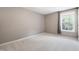 Neutral bedroom with plush carpeting, window view, and calming beige walls at 704 Voyager Pl, Durham, NC 27712