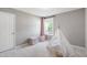 Light-filled bedroom with neutral walls, light carpet, and a decorative teepee in the corner at 704 Voyager Pl, Durham, NC 27712