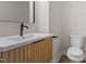 Modern bathroom featuring a sleek vanity with wooden accents and a contemporary black faucet at 730 Hopkins St, Durham, NC 27701