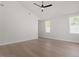 Bedroom with hardwood floors, ceiling fan, and natural light streaming through the windows at 730 Hopkins St, Durham, NC 27701