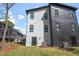 Side view of a modern two-story home with gray and black siding, black-trimmed windows, and an air conditioning unit at 730 Hopkins St, Durham, NC 27701