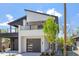 Modern home boasts a sleek design with a black garage door, white accents, and an open-air upper balcony at 730 Hopkins St, Durham, NC 27701