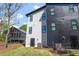 View of a two-story home with gray and black siding and an air conditioning unit at 730 Hopkins St, Durham, NC 27701