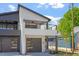 Contemporary home featuring a balcony, black garage door, and modern design elements at 730 Hopkins St, Durham, NC 27701