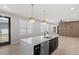 Open kitchen featuring island with sink and dishwasher, stainless steel appliances, and modern hanging light fixtures at 730 Hopkins St, Durham, NC 27701
