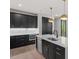 Stylish kitchen boasts black cabinetry, stainless steel appliances, and a central island with quartz countertop at 730 Hopkins St, Durham, NC 27701