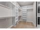 Spacious walk-in closet with custom shelving, racks, and wood flooring offers ample storage at 730 Hopkins St, Durham, NC 27701