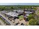 Aerial view of textile mill with manicured green space and large parking lot with trees, and the city in the background at 732 Hopkins St, Durham, NC 27701