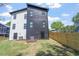 Side view of the modern home with backyard, featuring a well-maintained lawn and privacy fence at 732 Hopkins St, Durham, NC 27701