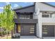 Modern two-story home with a black and white exterior, a covered balcony, and a two-car garage at 732 Hopkins St, Durham, NC 27701