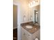 Bathroom with granite countertops, white cabinets, sink, large mirror, and open door to a room at 74 Revelstoke Dr, Garner, NC 27529