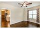 This spacious bedroom has hardwood floors, a window with curtains, and an open door to a kitchen at 74 Revelstoke Dr, Garner, NC 27529