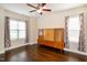 This bright bedroom features hardwood floors, neutral paint, ceiling fan, and two large windows at 74 Revelstoke Dr, Garner, NC 27529