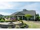 Clubhouse exterior with a stone firepit and lush landscaping that creates an inviting outdoor space at 74 Revelstoke Dr, Garner, NC 27529