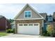 A well-maintained garage featuring a white door and stone accents on the exterior of the charming home at 74 Revelstoke Dr, Garner, NC 27529