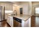 Kitchen island with granite countertop, stainless steel appliances, and hardwood floors at 74 Revelstoke Dr, Garner, NC 27529