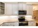 Contemporary kitchen with granite countertops, white cabinets, and stainless steel microwave and stove at 74 Revelstoke Dr, Garner, NC 27529
