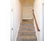 A carpeted staircase with a wooden handrail in a brightly lit home at 74 Revelstoke Dr, Garner, NC 27529